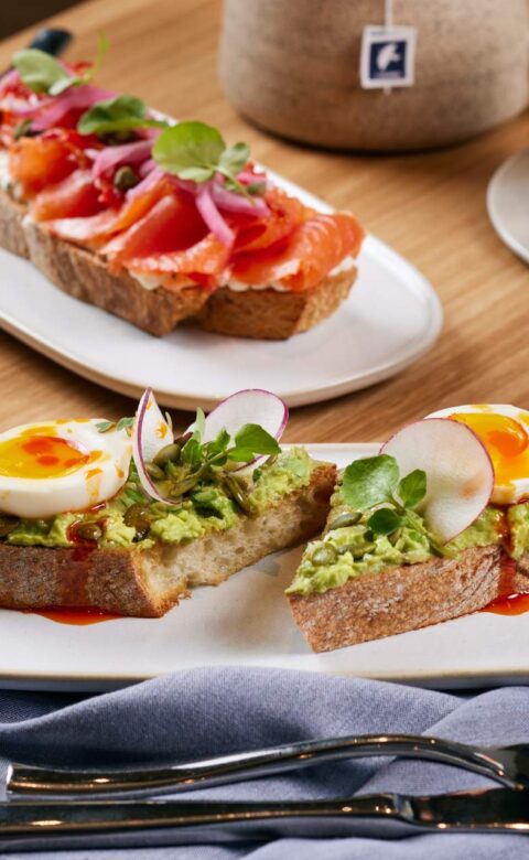two plates of food on a table with utensils